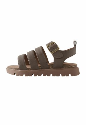 Sandale maro din piele cu patru barete, cataramă ajustabilă din alamă, talpă groasă texturată și buclă la călcâi pentru ușurința purtării.