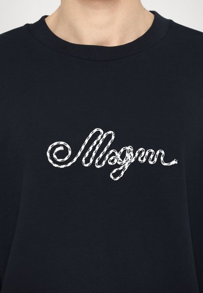 Námořnický crewneck svetr s bílým, texturovaným kurvovým písmem "Mogun" na hrudi, umístěným na jednobarevném podkladu.
