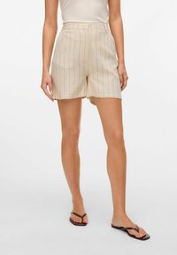 Linne shorts i ljusbeige med vertikala ränder, hög midja, och sidfickor. Har en avslappnad passform och fållade kanter.