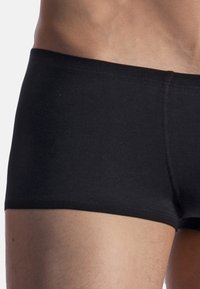 Black boxer briefs made from smooth fabric, featuring a snug fit with a low-rise waistband and no visible patterns or logos.