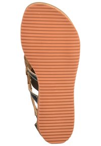 Semelle de sandale beige avec une texture en caoutchouc orange rainuré. Équipée de sangles et d'accents noirs, conçue pour le confort et l'adhérence.