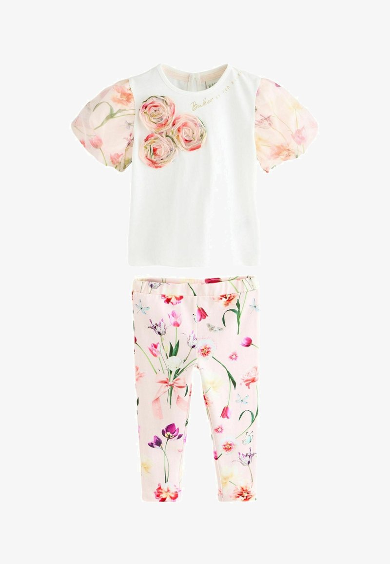 Bluză albă cu mâneci puff florale roz și trei aplicații în formă de trandafir; colanți roz asortați, împodobiți cu un imprimeu floral multicolor.