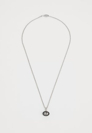 Collier en argent avec un pendentif ovale présentant une surface texturée et un détail de pierre précieuse centrale, sur fond blanc.