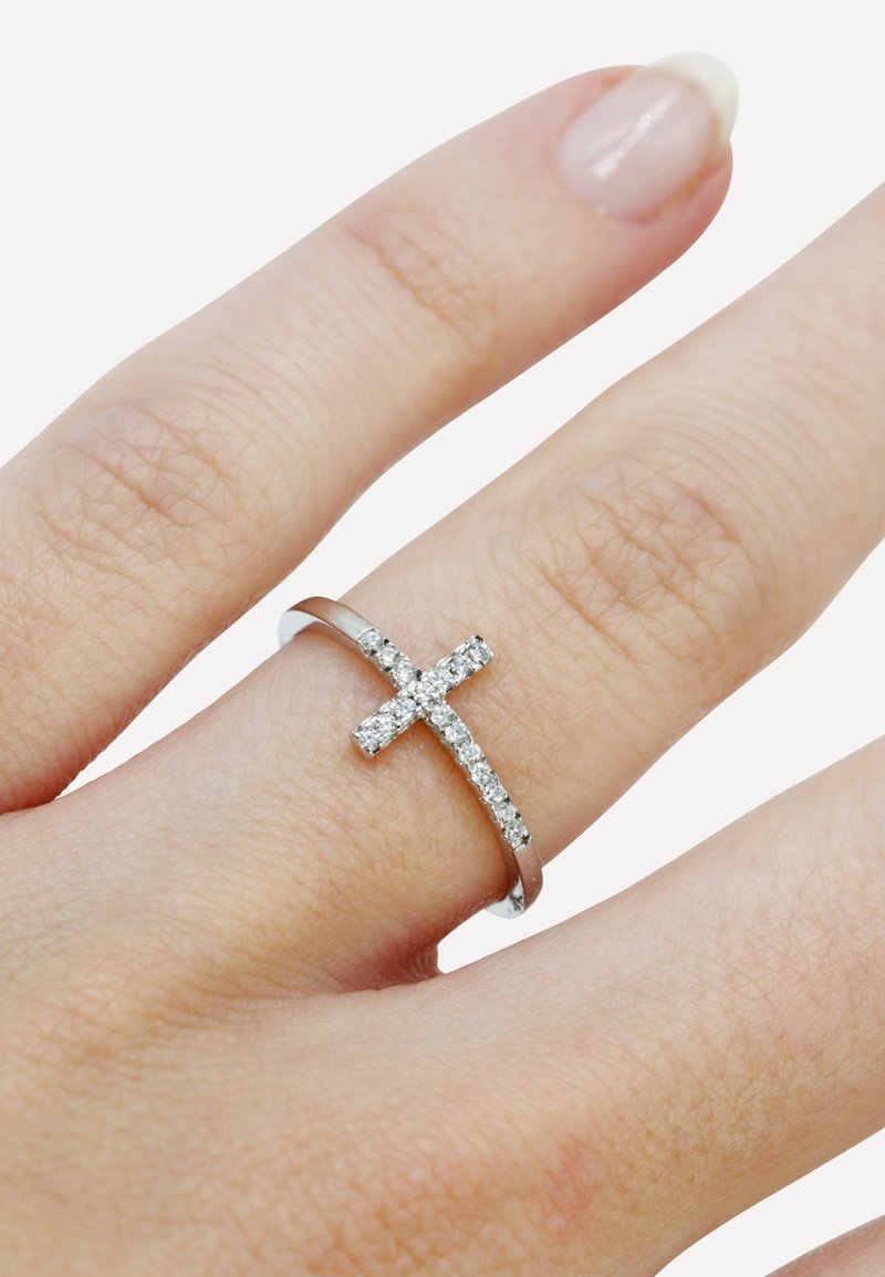 Silver band ring featuring a cross design adorned with clear, sparkling gemstones. The band is smooth, and the cross is slightly raised.