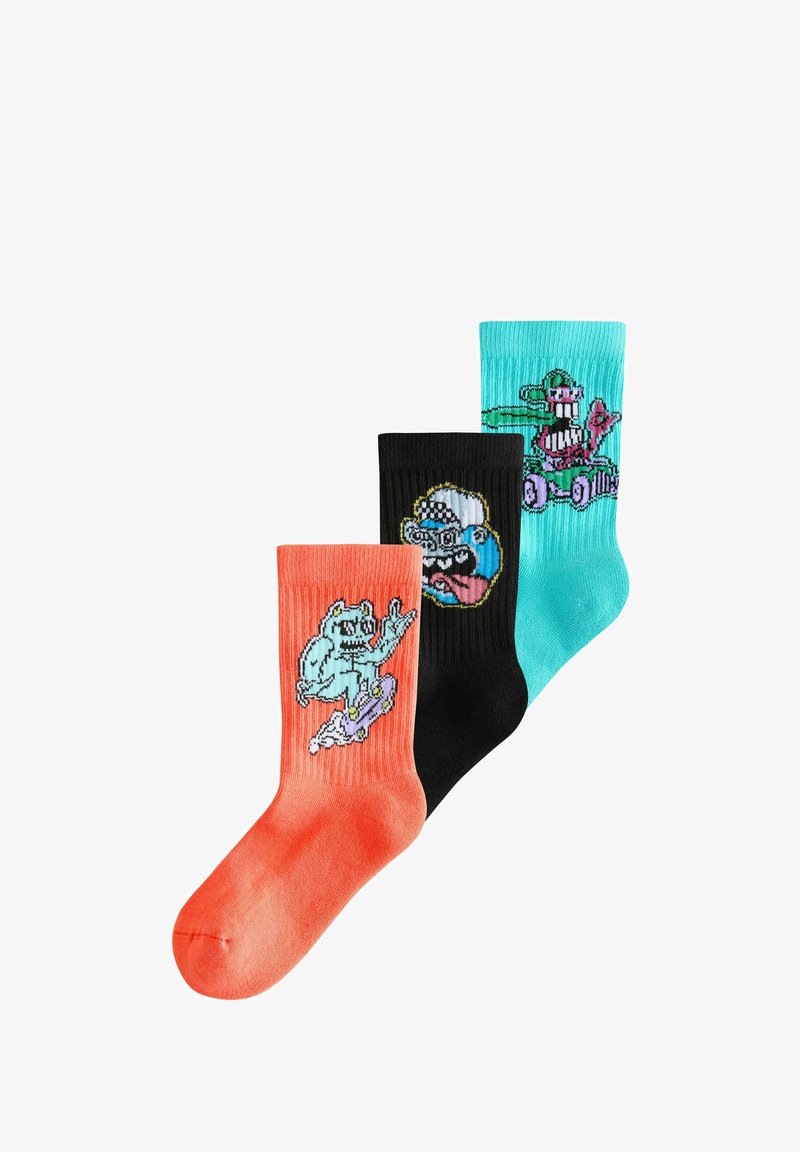 Drei bunte Kniesocken mit Cartoon-Figuren: orange mit einer Skateboard-fahrenden Kreatur, schwarz mit einem Gesicht mit herausgestreckter Zunge und türkis mit einem Fahrer im Auto.