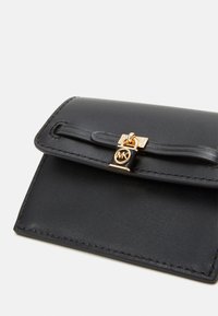 Black leather wallet with a gold clasp featuring a logo. The design includes a smooth texture and neat stitching around the edges.