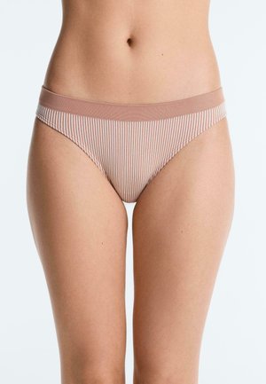 Woman wearing beige and white striped bikini-style underwear, shown from waist to mid-thigh against a plain background.