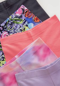 Fünf Paare von bunten Leggings flach angeordnet: schwarz mit buntem Druck, pink, sanfter Verlauf, lavendel, korallenrot. Eigenschaften umfassen dehnbare Stoffe und Nähte.