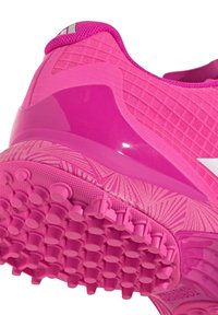 Scarpa atletica rosa brillante con tomaia testurizzata, intersuola strutturata e suola in gomma dotata di tacchetti circolari per la trazione.