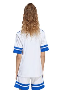 Maillot de sport blanc avec des rayures bleues sur les manches, conçu pour le confort. Comprend un short assorti avec des rayures bleues horizontales.