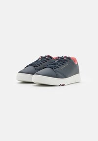 Sneakers in pelle blu navy con accenti rosa, suole in gomma bianca e lacci neri. Presentano il logo sul lato e un dettaglio a righe vicino alla suola.