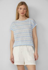 Lichtblauwe gestreepte t-shirt gemaakt van zachte stof met opgerolde mouwen, gecombineerd met witte broekjes met trekkoord, met een ontspannen pasvorm en subtiele textuur.