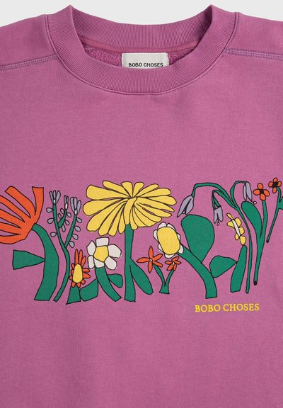 Sweat-shirt violet avec des fleurs dessinées à la main en jaune, orange, blanc et vert sur la poitrine, et le texte "BOBO CHOSES" en jaune.