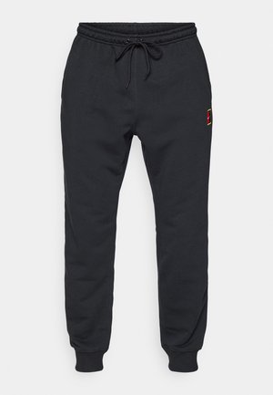 Black jogger pants with elastic waistband and ankle cuffs, drawstring at waist, and small red and yellow logo on upper thigh.