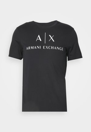 Juodas medvilnės marškinėliai su apvaliu apykaklėle. Priekyje užrašas "A|X ARMANI EXCHANGE" baltu šriftu. Reguliari forma, trumpomis rankovėmis.