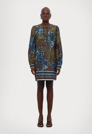 Robe imprimée avec des manches longues, un col rond avec un détail à nouer, et un mélange de motifs floraux et abstraits bleus, oranges et blancs.