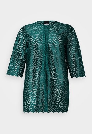 Teal lace blouse with a leaf pattern, round neckline, and three-quarter sleeves. Semi-sheer fabric with scalloped hem and button closure.