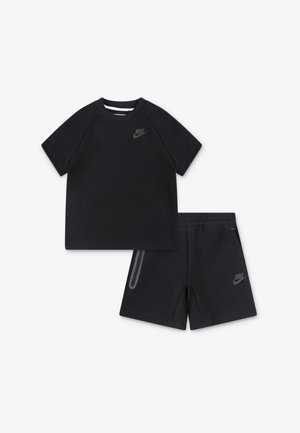 Melnas kokvilnas T-krekls ar īsām raglan piedurknēm un pelēku Nike logotipu, kopā ar atbilstošām šortiem, kas aprīkoti ar sānu kabatu un logotipu.