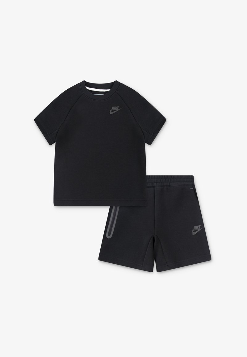 Čierne bavlnené tričko s krátkymi raglánovými rukávmi a sivým logom Nike, spárované s matching šortkami, ktoré majú bočnú kapsu a logo.