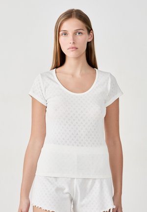 Top bianco a maniche corte con scollatura rotonda, caratterizzato da un motivo testurizzato di piccoli diamanti. Tessuto liscio e design aderente.