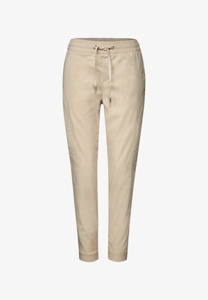 Pantalones jogger de mezcla de algodón beige con cintura de cordón, piernas ajustadas, bolsillos laterales y textura suave. Presentan un diseño casual y relajado.
