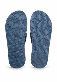 Vista inferiore di sandali blu scuro con motivo di tacco geometrico su uno sfondo bianco.