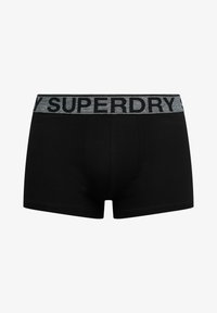 Boxer cortos negros con una banda elástica gris que presenta el nombre de la marca "SUPERDRY" en letras negras. Hechos de un material suave y elástico.