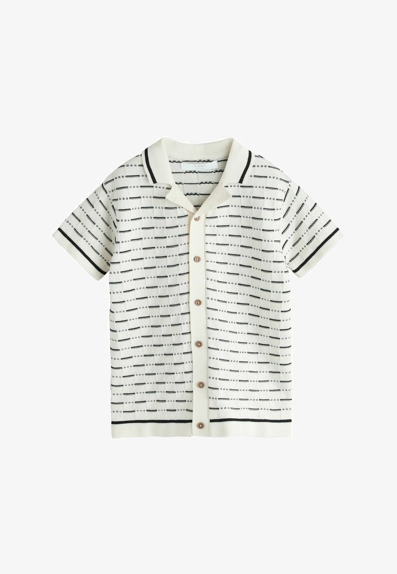 Kurzärmeliges weißes Strickshirt mit schwarz gepunktetem horizontalem Streifenmuster, Knopfleiste vorne und Kragen mit schwarzem Besatz.