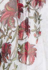 Tejido transparente con un patrón floral con acentos rojos y verdes. Diseño ligero y texturizado con ilustraciones detalladas de hojas y flores.