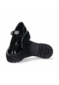 Scarpe Mary Jane in vernice nera con una suola larga e chunky, punta rotonda e cinturino regolabile con una fibbia color oro.