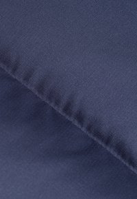 Tessuto navy con una texture liscia; presenta linee diagonali e una lucentezza sottile, creando un aspetto moderno. I bordi sono rifiniti con cura.