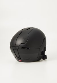 Czarny kask narciarski o aerodynamicznym kształcie, z otworami wentylacyjnymi, z wbudowanym systemem audio, regulowanym paskiem na brodę oraz metką technologii RECCO.