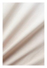Tessuto di un beige chiaro con una texture liscia, che mostra pieghe gentili e una leggera lucentezza, adatto a vari utilizzi tessili.