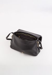 Czarna skórzana torba na ramię o fakturowanej powierzchni, z zamknięciem na zamek błyskawiczny, złotymi akcentami oraz pojemnym wnętrzem z wieloma przegrodami.