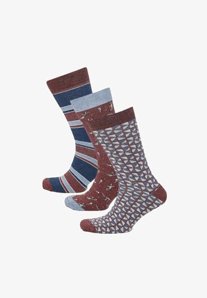 Trois paires de chaussettes mi-mollet avec des motifs géométriques, rayés et abstraits dans des tons bleus, bordeaux et gris, affichées côte à côte.