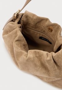 Καφέ σουέντ τσάντα με σχεδιασμό με σούρες, που διαθέτει λείο εσωτερικό επένδυση, μικρή τσέπη με φερμουάρ και διακοσμητικό σε χρυσαφί απόχρωση.