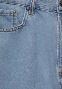 Tissu en denim bleu clair avec une texture lisse, comportant une poche avant et des coutures orange contrastantes le long des bords et des coutures.