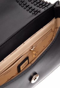 Borsa sintetica nera con dettagli in tessuto intrecciato, interno beige con una tasca con zip e etichetta marchiata, chiusa da un bottone a scatto dorato.