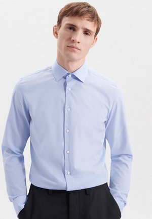 Camicia azzurra a maniche lunghe con colletto strutturato, realizzata in tessuto morbido; presenta bottoni bianchi e una vestibilità slim.