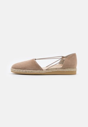 Espadrille plate en daim beige avec semelle en jute tressée et sangles élastiques croisées sur le côté pour un maintien sûr.