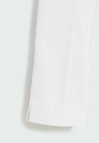 Pantalones ajustados blancos con pierna recta, que presentan una textura suave y una abertura lateral en el dobladillo para un detalle adicional.