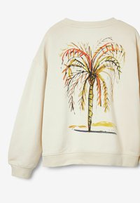 Sudadera color crema con una ilustración de una palmera en rojo, verde y amarillo. Corte relajado con puños y dobladillo acanalados.