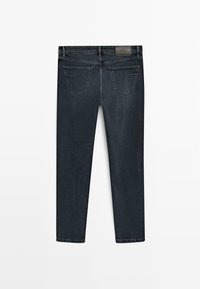Jeans dritti grigi scuri visti da dietro, con due tasche posteriori e un piccolo patch in pelle del marchio sulla vita.