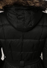 Sort puffer-jacket med quiltet design, indsnævret talje og aftagelig faux fur-krave. Har et glat, tekstureret stof.