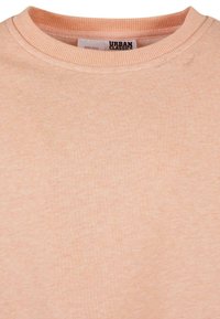 Felpa rosa chiaro con collo a girocollo a costine, realizzata in tessuto morbido, con una sottile texture e un piccolo etichetta del logo all'interno del colletto.