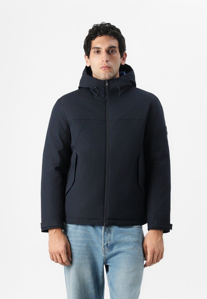 Navy hooded jacket made from soft, water-resistant fabric. Features a zip front, two side pockets, and a relaxed fit for comfort.