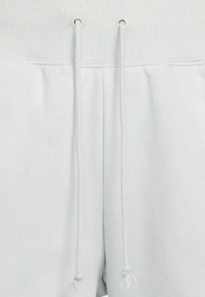 Pantaloni corti bianchi in felpa con un elastico a costine in vita, dotati di cordoncino e due tasche frontali. Tessuto liscio con dettagli di texture sottili.