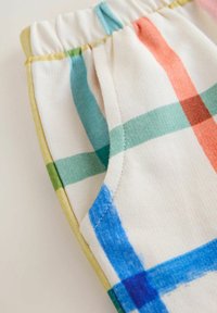 Puuvillast lühikesed püksid elastse vöökohaga, millel on mitmevärviline ruuduline muster, hõlmates siniseid, rohelisi, roosaid ja oranže triipe.