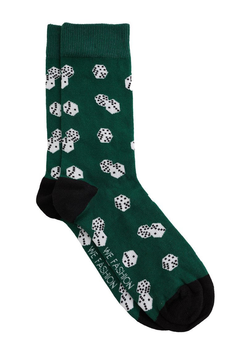 Calcetines verdes con talones y punteras negras, decorados con un patrón de dados blancos que muestran varios números.