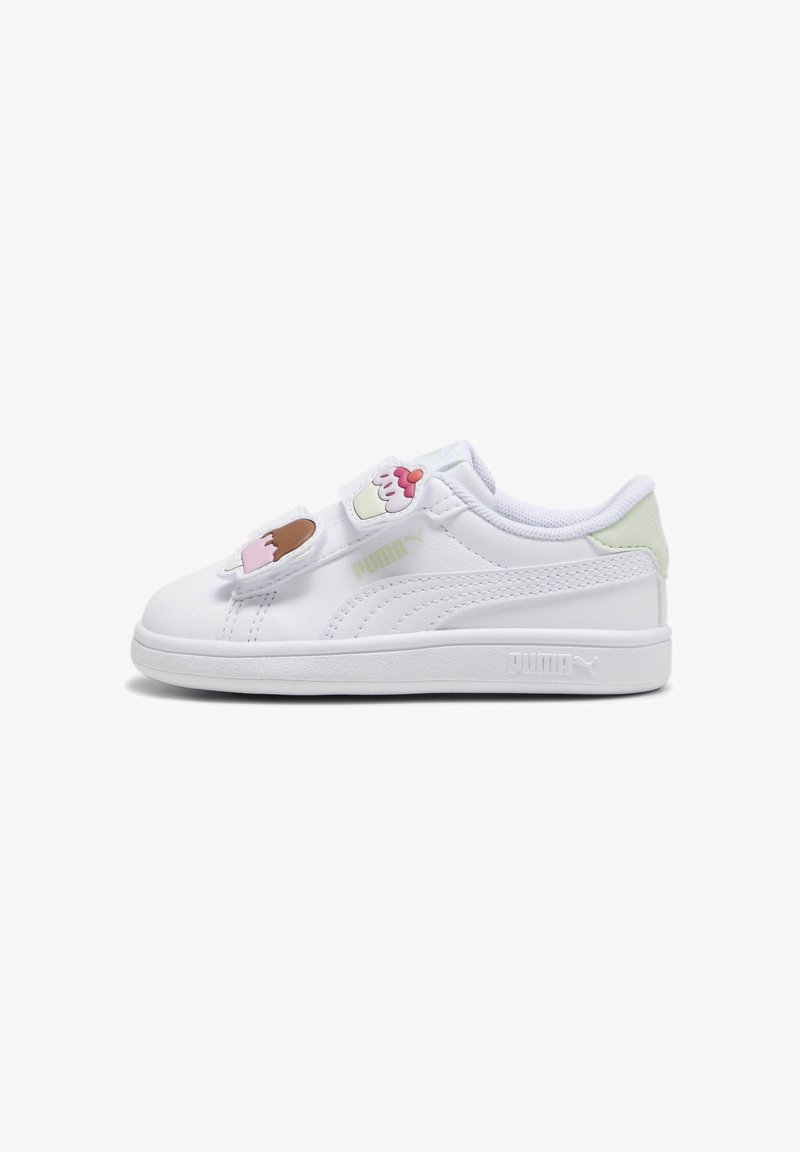 Baskets blanches Puma avec des brides à patchs cupcake et glace et détail talon vert clair, vues de côté sur fond blanc.